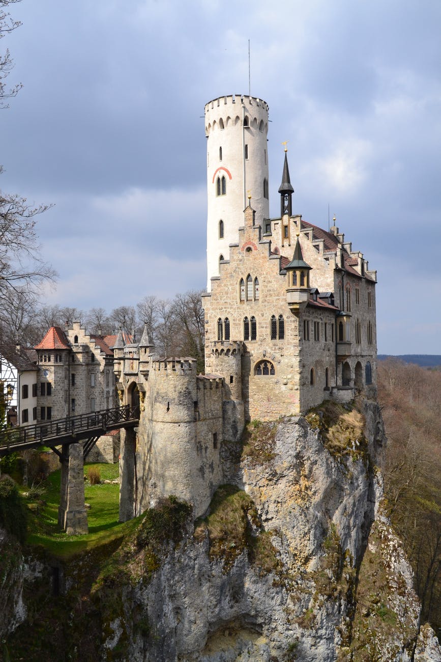 gray and white castle built near a cliff