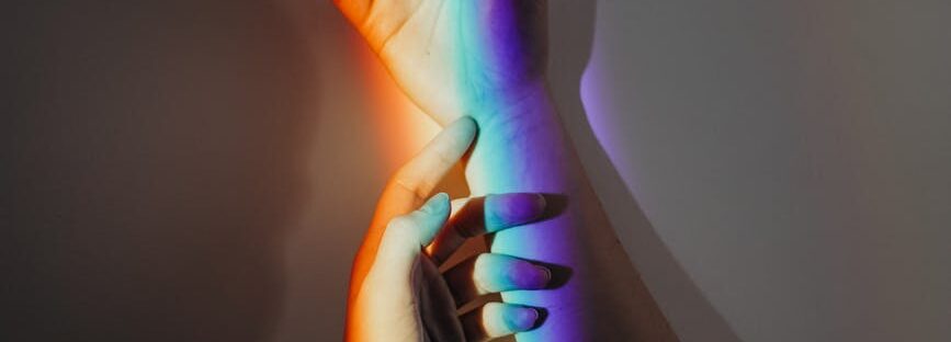 persons hands with rainbow colors