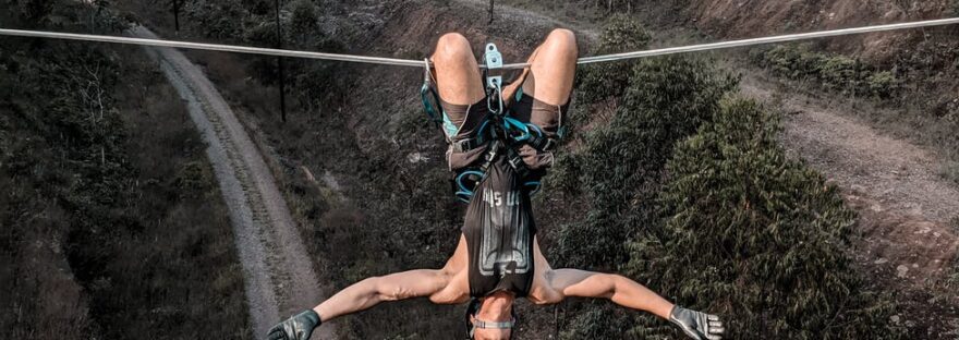 man in black tank top hanging on a rope