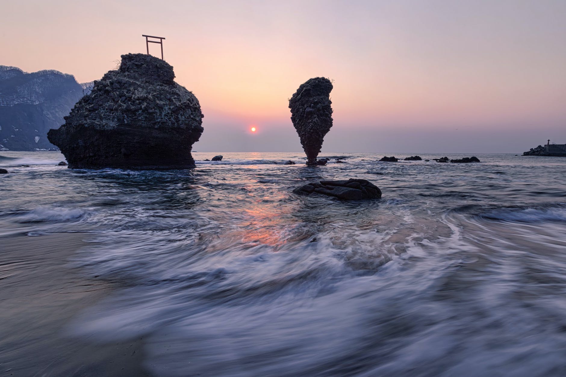 cliffs in sea near coast at sunset