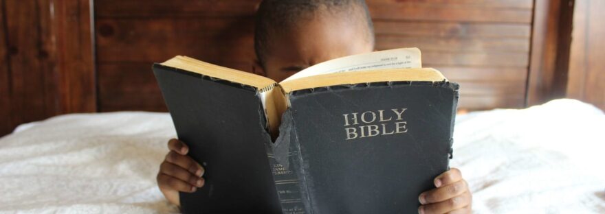 photo of child reading holy bible