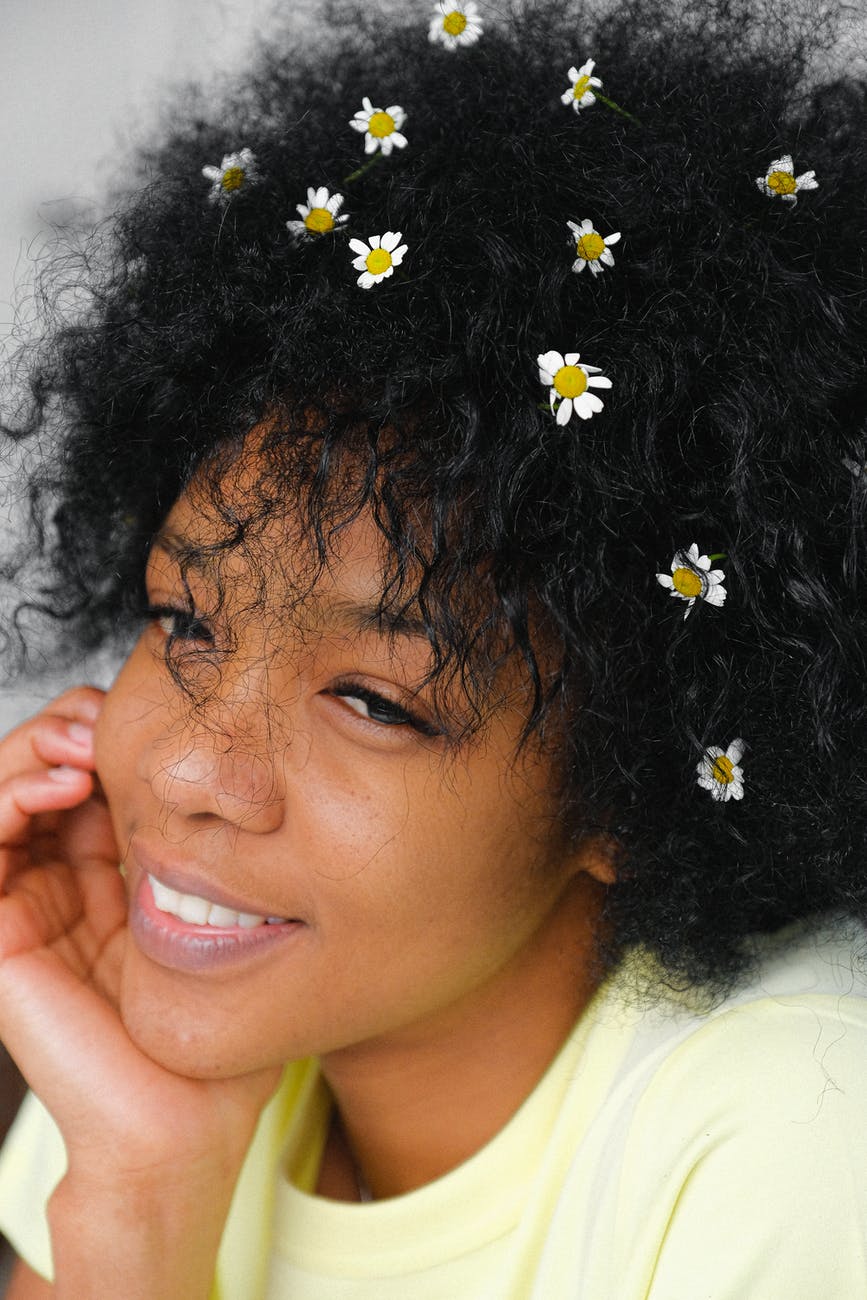 romantic black woman with chamomiles in hair