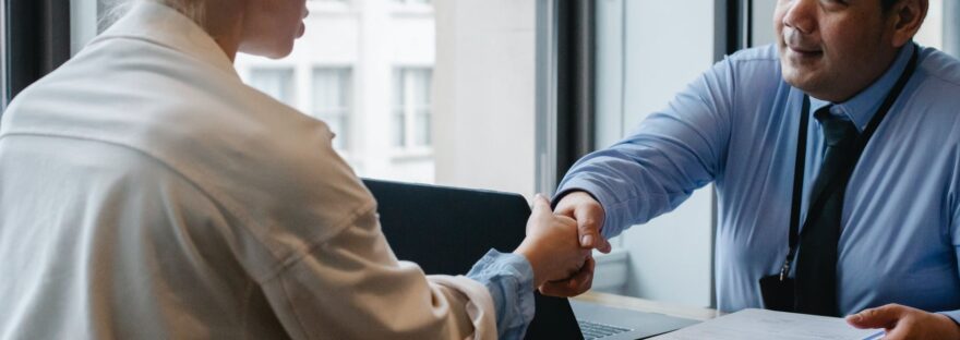 ethnic businessman shaking hand of applicant in office