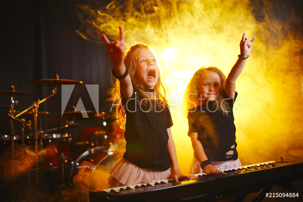 little girl play on synthesizer in music studio