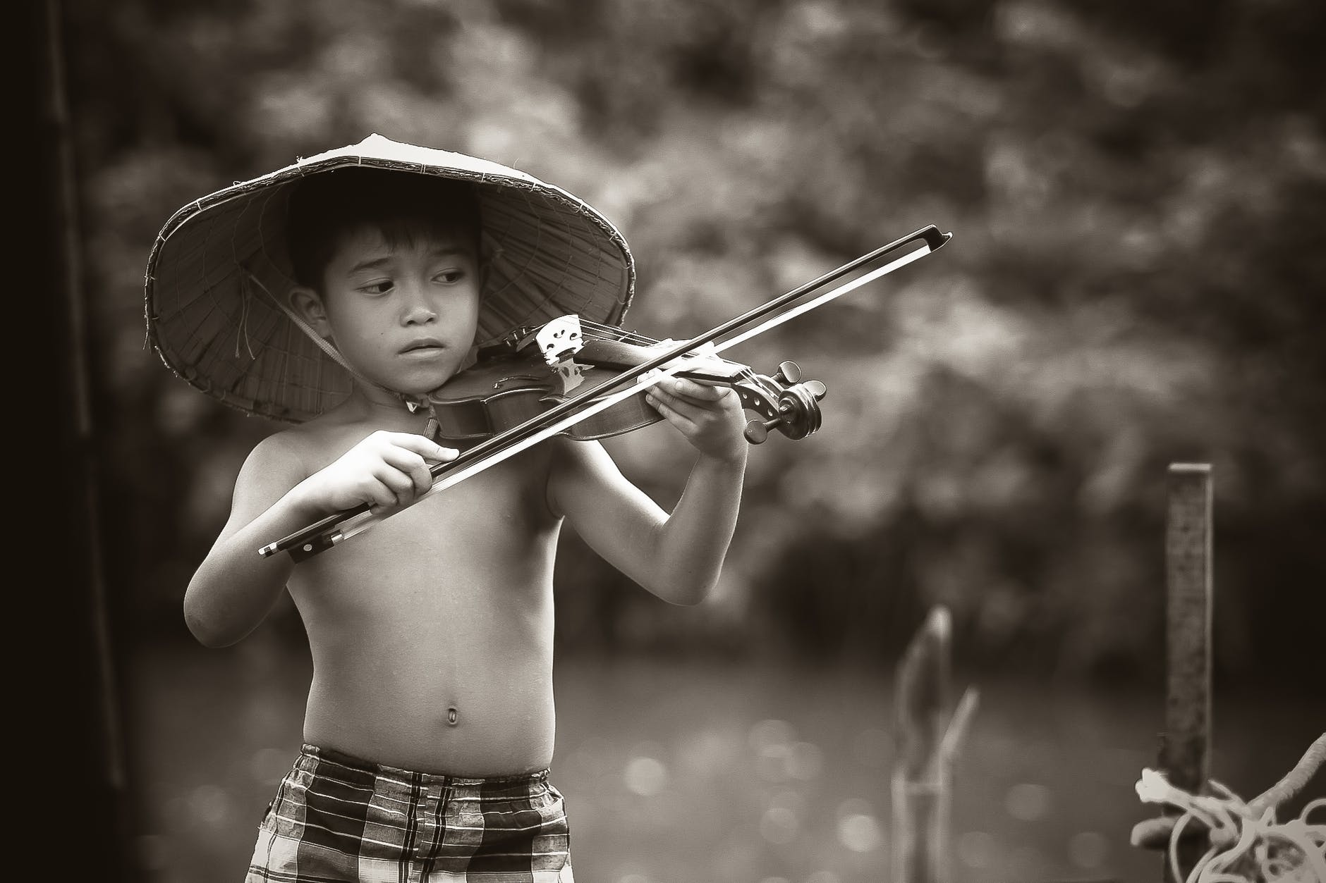 grayscale photography of boy playing violin