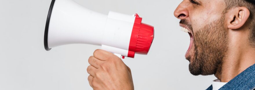 man in blue denim jacket holding a megaphone