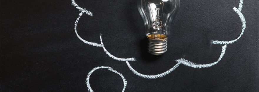 clear light bulb placed on chalkboard