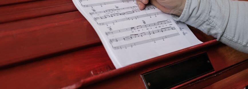 person writing on the sheet music