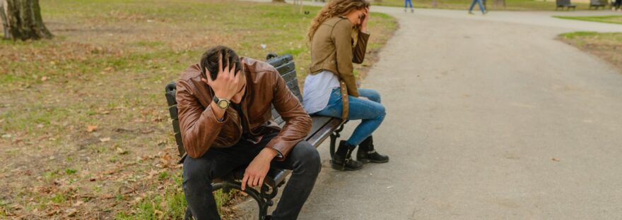 man and woman sitting on bench