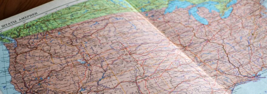 map of the world book laid open on brown wooden surface