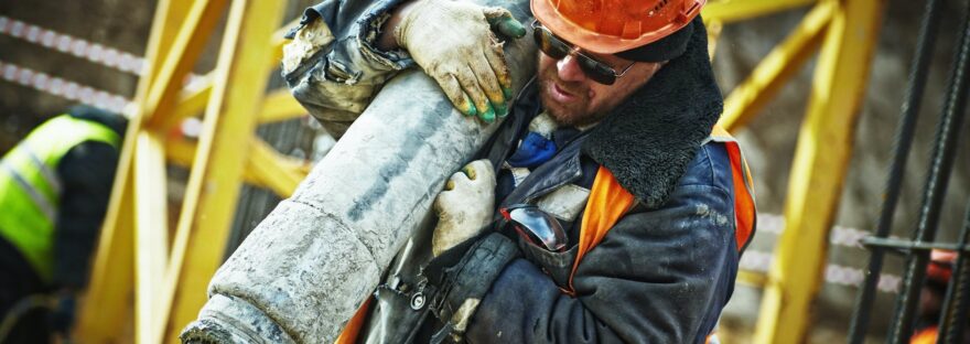 man carrying gray pipe