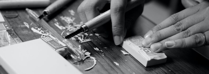 grayscale photo of person carving block