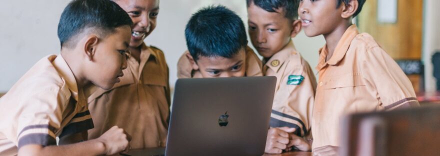 boy using silver macbook indoors