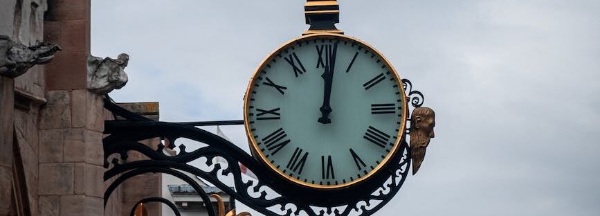 clock hanging on the side of a building